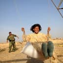 Kamaran Najm, Kirkuk, Iraqi Kurdistan, 2009, forces from the District Police of Kirkuk Governate, which consists of a mix of Arab, Kurd and Turkmen, are pushing a child on a swing near Hawija, whilst on duty to find terrorists in the area.
