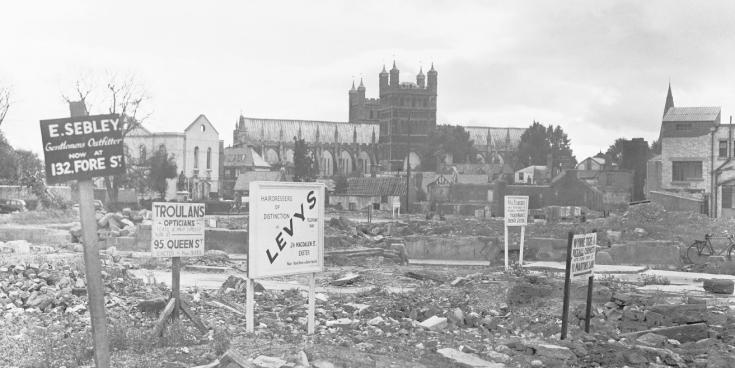 Signboards advertising new locations of shops that once stood on Exeter High Street before their demolition following the Blitz