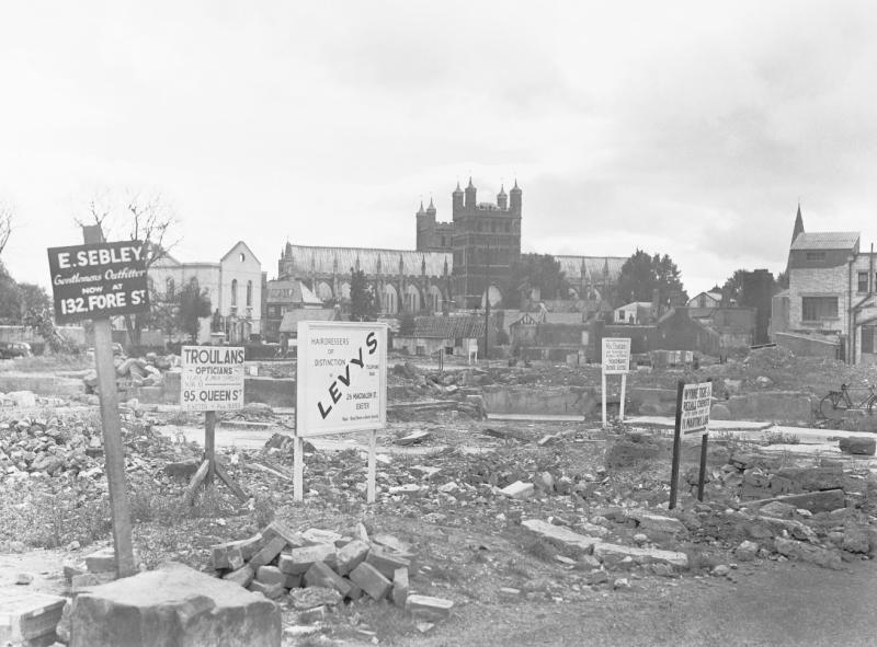 Signboards advertising new locations of shops that once stood on Exeter High Street before their demolition following the Blitz